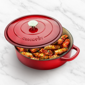 vas de fonta rosu crockpot pe masa cu mancare inauntru